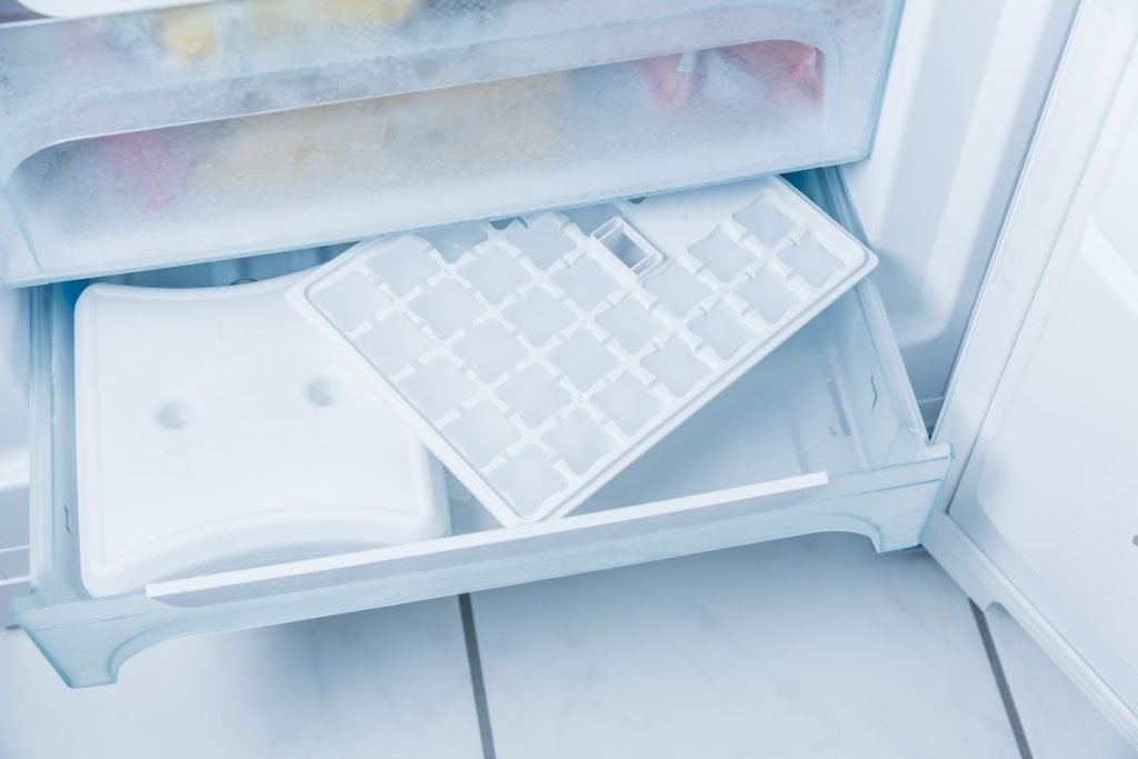 A refrigerator filled with various food items and ice trays, showcasing organized storage and freshness.