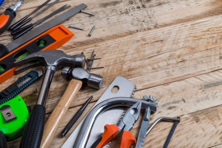 A wooden table displaying a variety of tools, including wrenches, screwdrivers, and pliers, arranged neatly.
